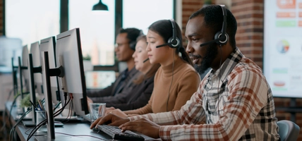 Male employee using headphones and microphone at customer care service.