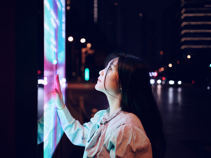 Young woman using touch screen on the street in Shanghai, China