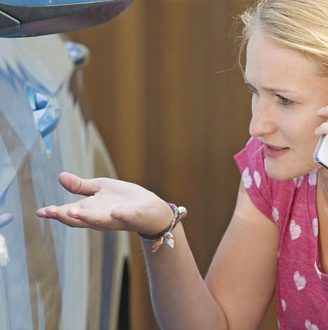 woman phoning insurance to report car damage