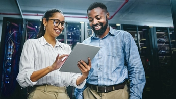 Shot of two young technicians using a digital tablet while working in a server room