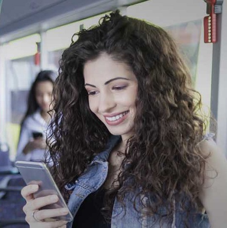 woman looking at phone on bus