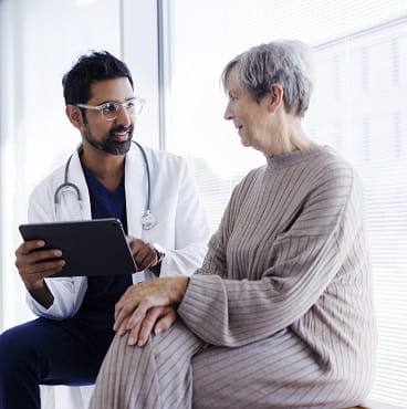 Doctor and patient in conversation, looking at digital tablet