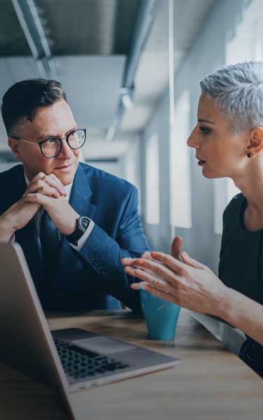 Business professionals having a conversation over a laptop