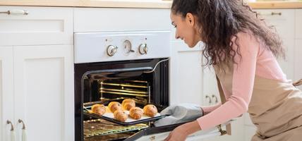 woman taking food out of an oven