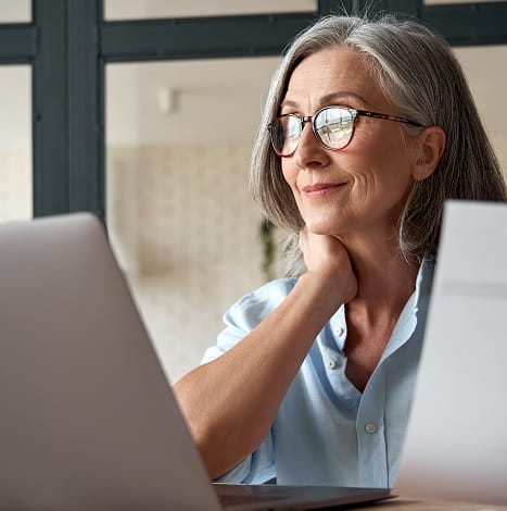 older woman looking at screen smiling