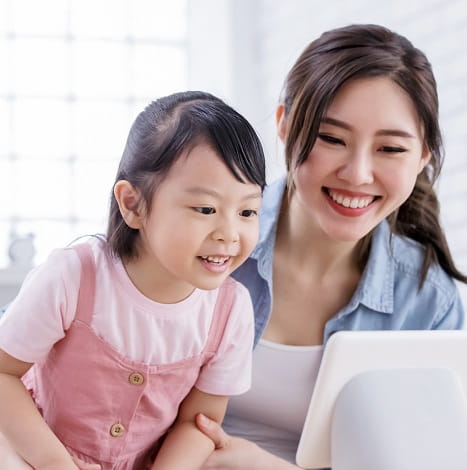 mother and daughter smiling at screen