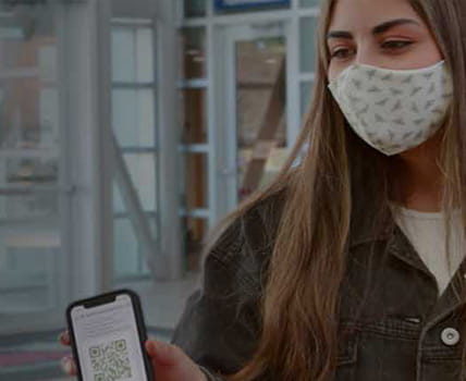 student wearing mask showing mobile app