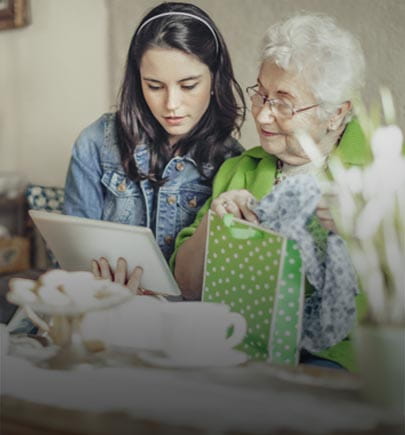 Elderly lady vieweing device with young woman