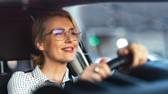 Smiling business woman traveling with her car around the city.