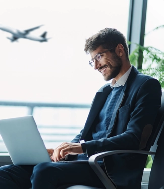 Tired passenger using a laptop in the waiting room