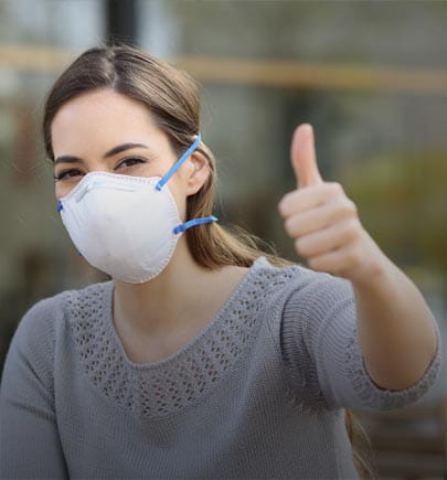 woman wearing mask and doing thumbsup