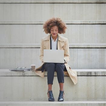 young businesswoman using laptop on steps