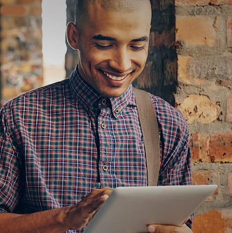 man smiling holding tablet