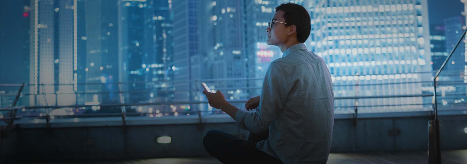 Young businessman looking at smartphone on the roof