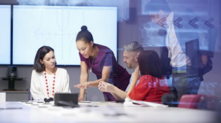 Office workers deliberating over computer