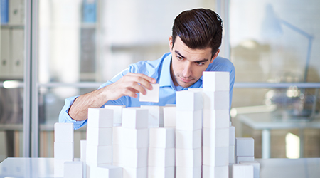 Businessman building towers with blocks