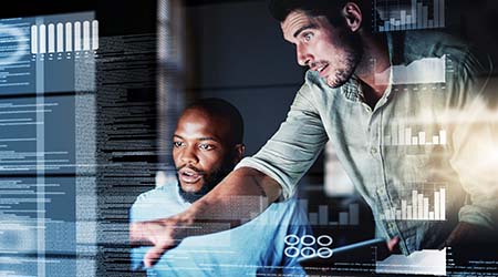 Two co-workers pointing at diagnostic screens