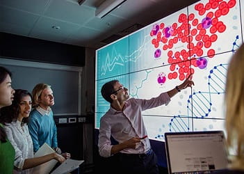 man standing at interactive screen teaching