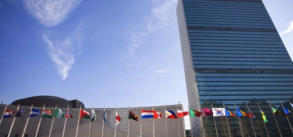 Colorful flags of the world, blowing in the wind in front of the United Nations UN Building. Plenty of room for your text.