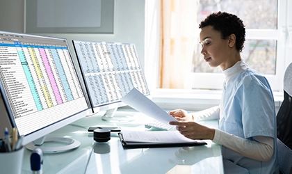 female medical worker review documents by computer screen