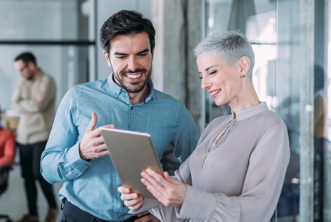 Shot of two coworkers having a discussion in modern office