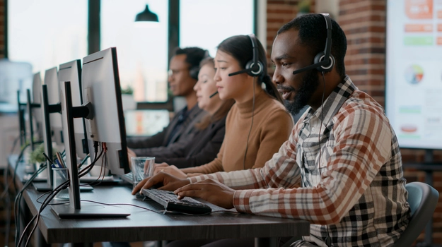 Male employee using headphones and microphone at customer care service.