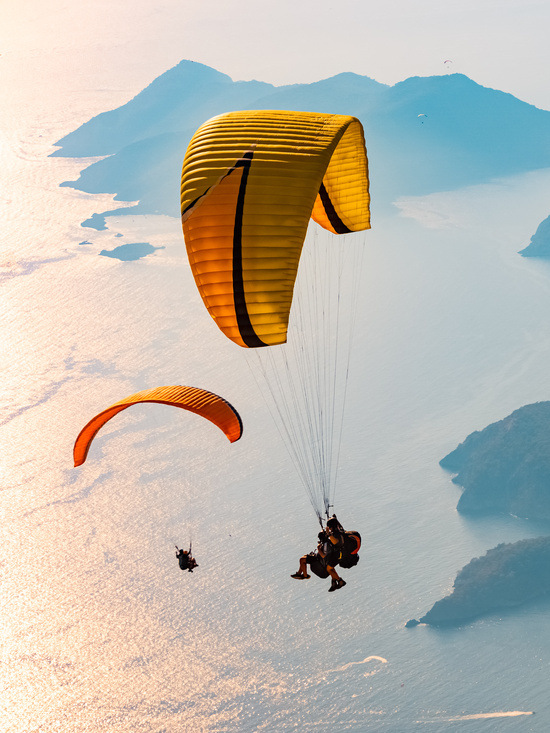 Paraglider tandem flying over the Oludeniz at sunset. Fethiye, Mugla.
