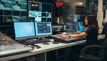Young beautiful woman working in a broadcast control room on a tv station