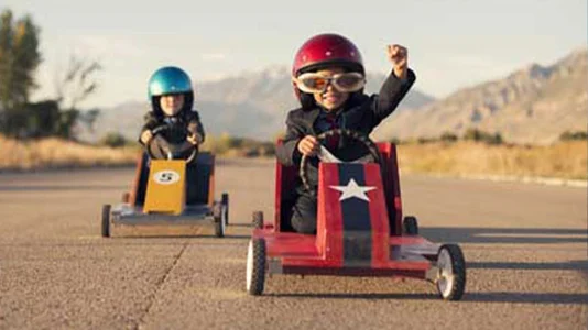 Young Business Boys in Suits Race Toy Cars