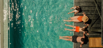 Photo of a young family with two children, relaxing by the pool in a vacation rental villa
