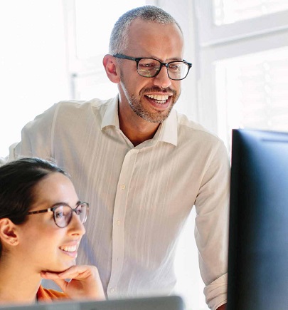 male and female colleagues watching computer screen and smiling