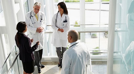 A group of doctors hold a discussion in a lab setting