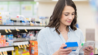 Woman in drug store looking at phone