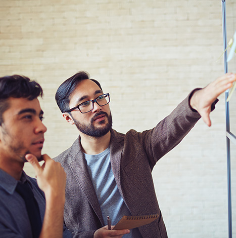 Man Standing Near Whiteboard and Pointing on the board