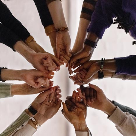 people putting hands in a circle