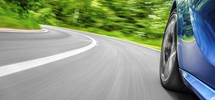 Motion blur shot of a car driving on a curved road