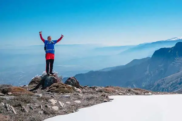 Senior mountain climber is watching the beautiful landscape of the mountain range