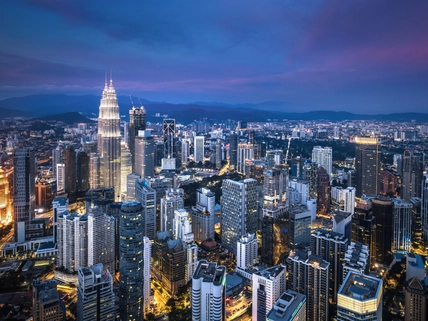 Aerial view of Kuala Lumpur skyline at dusk.