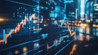 Stock market data displayed on a screen with a blurred city backdrop at night.