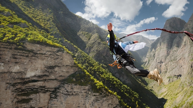 person jumping from cliff