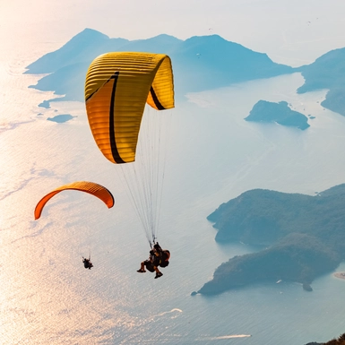 Paraglider tandem flying over the Oludeniz at sunset. Fethiye, Mugla.