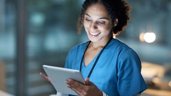 Nurse, medical tablet and black woman in hospital working late on telehealth, research or online consultation. Tech, healthcare or female physician with technology for wellness app in clinic at night