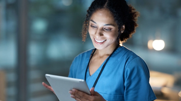 Nurse, medical tablet and black woman in hospital working late on telehealth, research or online consultation. Tech, healthcare or female physician with technology for wellness app in clinic at night