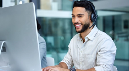 man sitting at desktop with headset