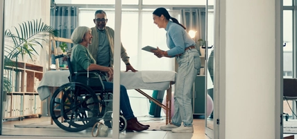 Senior, physiotherapy and couple with doctor and tablet for a consultation and person with disability. Rehabilitation, patient and woman speaking to a physiotherapist with tech for medical advice