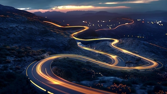 winding roads at night with car lights in motion