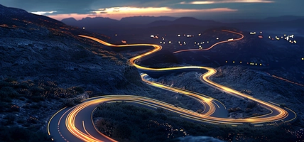 winding roads at night with car lights in motion