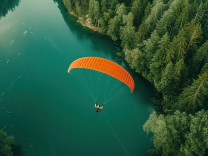 person paragliding over water and trees