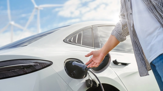 EV car with electric vihicle charging station, sustainable energy. nature green energy Wind turbines. Sustainability