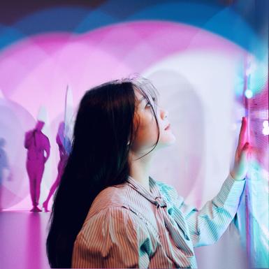 woman touching screen with lights and shadows behind her